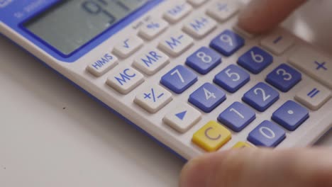 hand uses calculator in calculating numbers. closeup