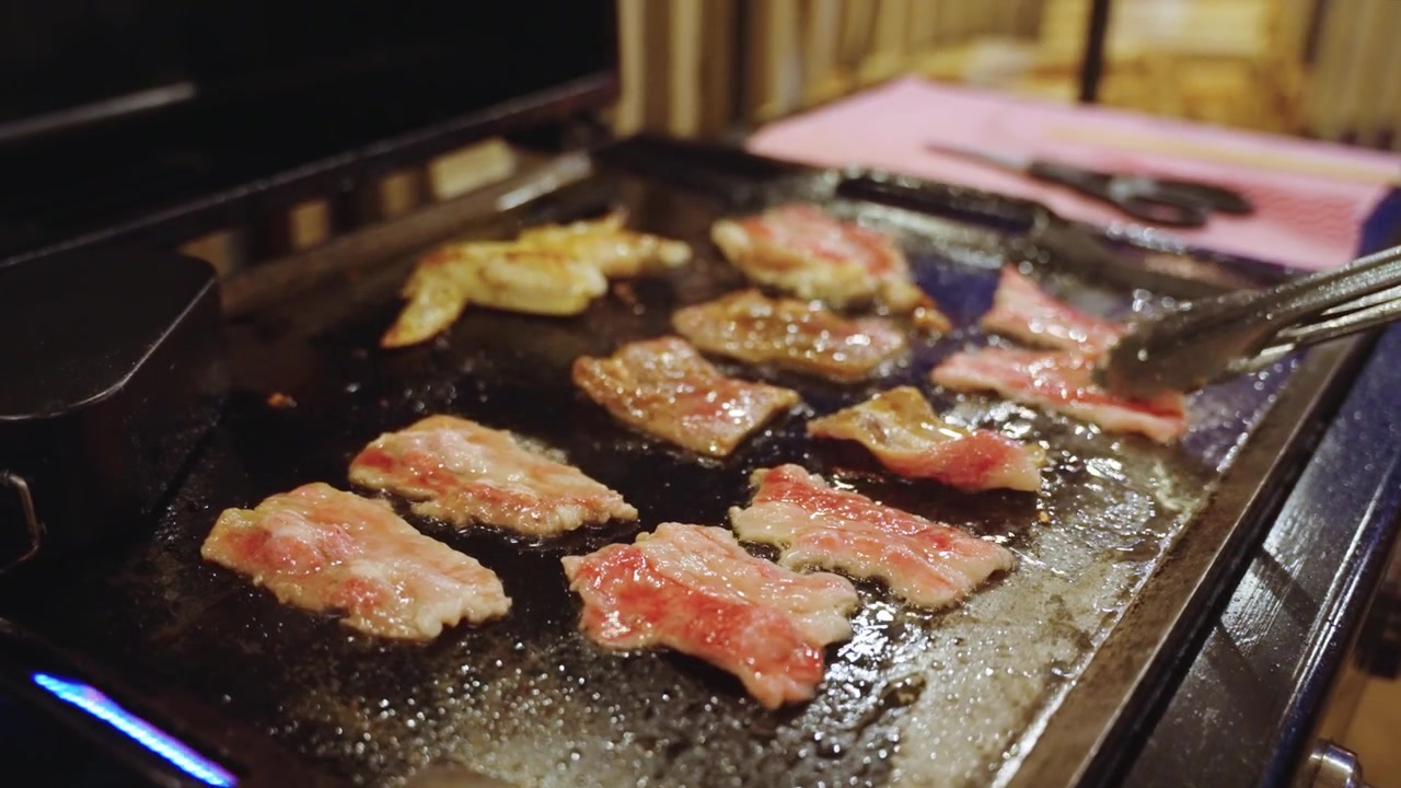グリルでジュージュー焼ける肉、調理中のカルビ肉の細切り
