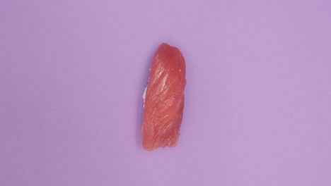 Sushi-roll-rotating-on-violet-background