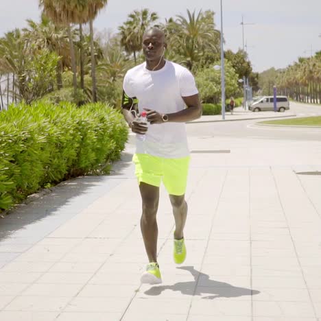 man wearing bright yellow shorts and music device