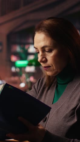 vertical video determined woman writing thesis citations from a specialty book at the library