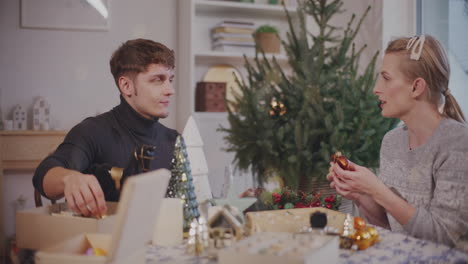 Woman-talking-to-friend-with-Christmas-decoration-on-table