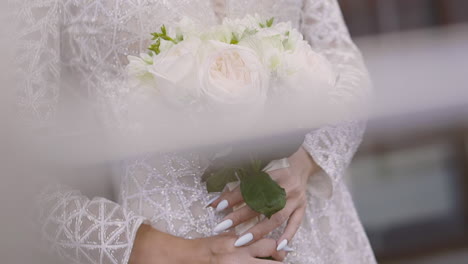 Una-Mujer-Delgada-Con-Un-Vestido-De-Novia-Brillante-Sostiene-Rosas-Blancas