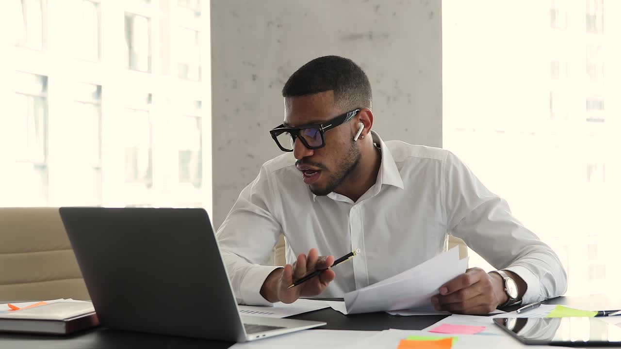 African businessman talk on videoconferencing sit at desk in office