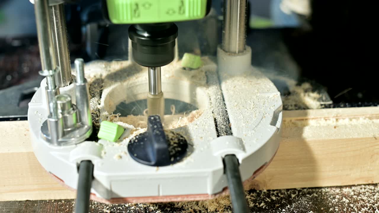 가정 작업실에서 수동 전기 절단기로 작업하는 목수의 손의 클로즈업입니다.