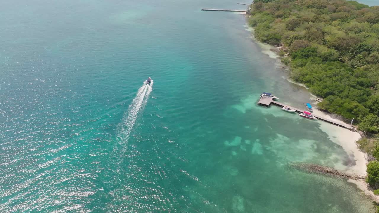 Drone view of Isla Grande in Rosario Islands, Colombia, surrounded by crystal clear Caribbean waters, coral reefs and lush tropical scenery