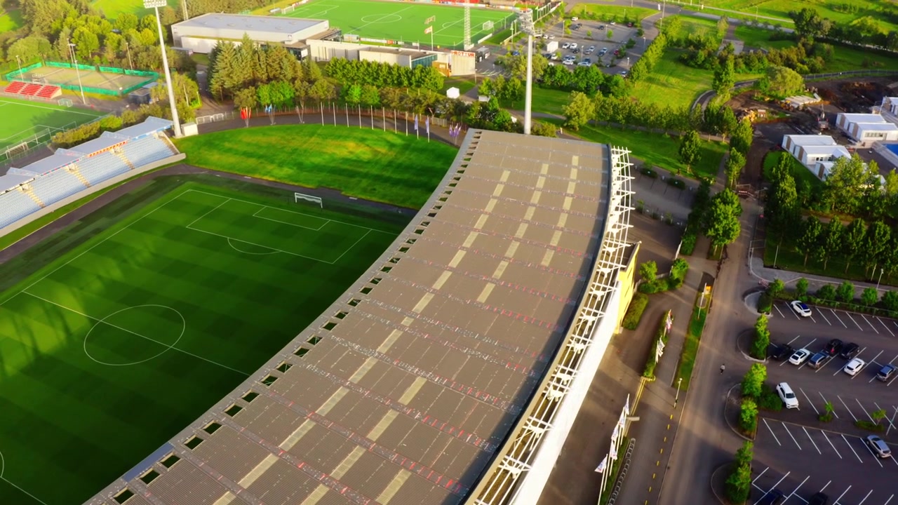 Eine Luftaufnahme mit einer Drohne fliegt über Laugardalsvöllur, das nationale Fußballstadion in Reykjavik, Island, und zeigt das Spielfeld, die Tribünen und den Parkplatz.