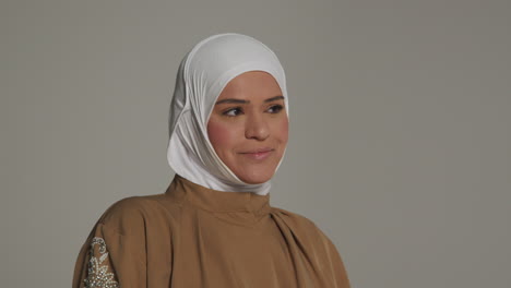 Studio-Head-And-Shoulders-Portrait-Of-Smiling-Muslim-Woman-Wearing-Hijab