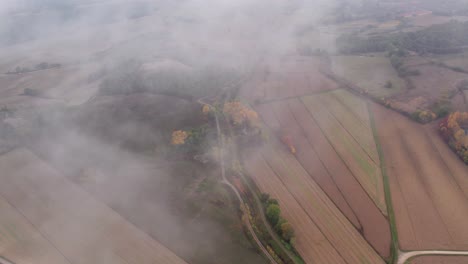 Volando-A-Través-De-La-Niebla-Sobre-El-Campo-Rural-De-Toscana,-Aéreo