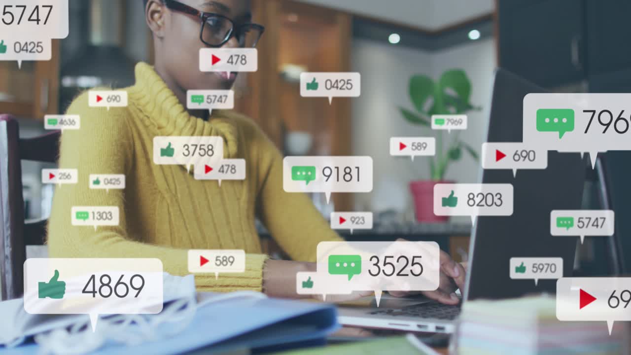 Animation of social media icons and numbers over african american woman using laptop