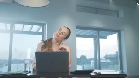 mujer de negocios estirando los brazos. mujer cansada relajándose en un lugar de trabajo remoto.