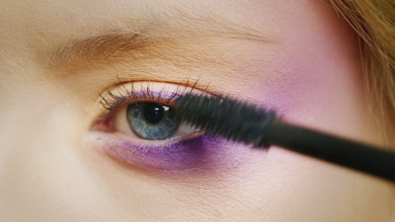 aplicar maquillaje en un hermoso ojo femenino de color azul