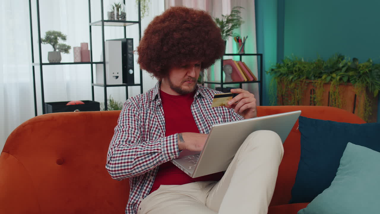 Young man using credit bank card and laptop, transferring money, purchases online shopping