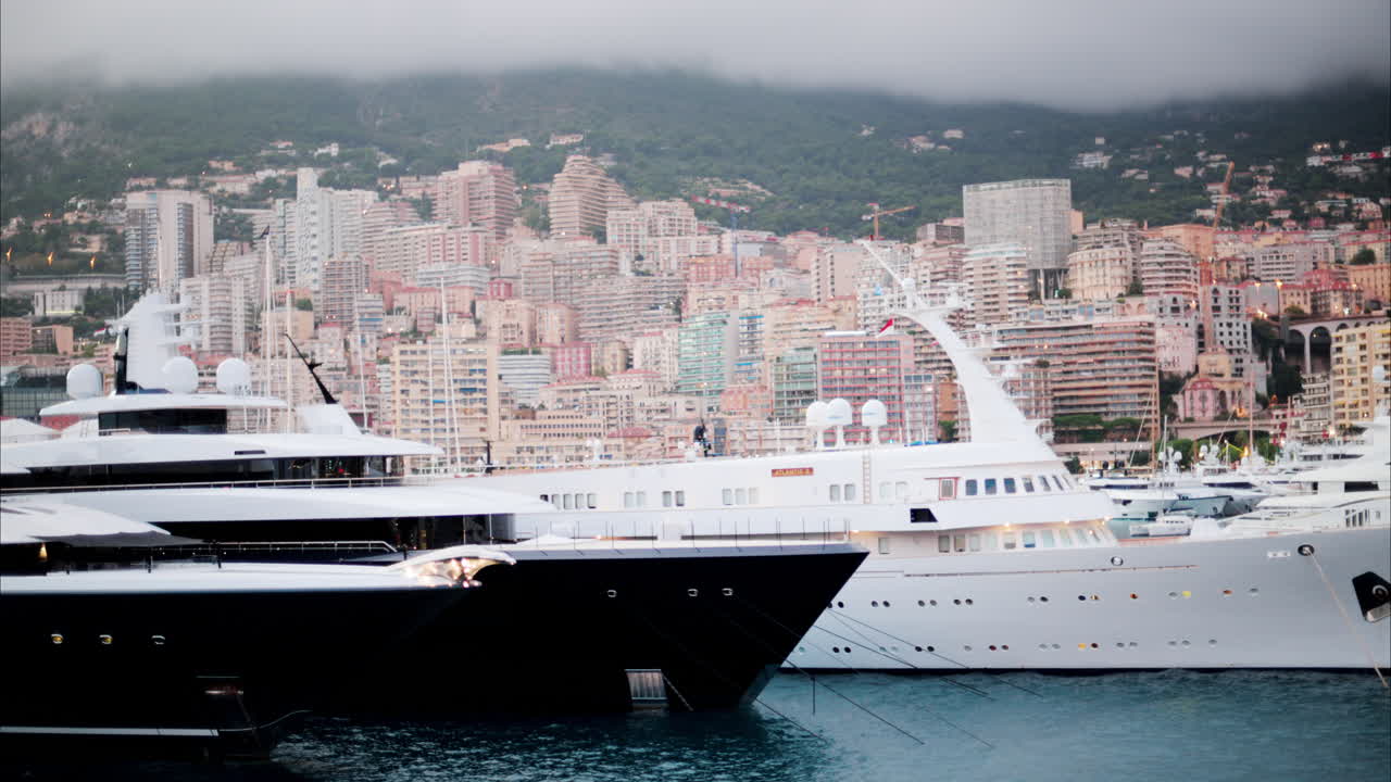 View of boats docked in the Monaco Marina with the skyline of the city on the background