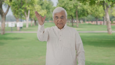 angry indian old man shouting on someone in park