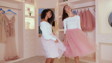 two women dancing in a closet