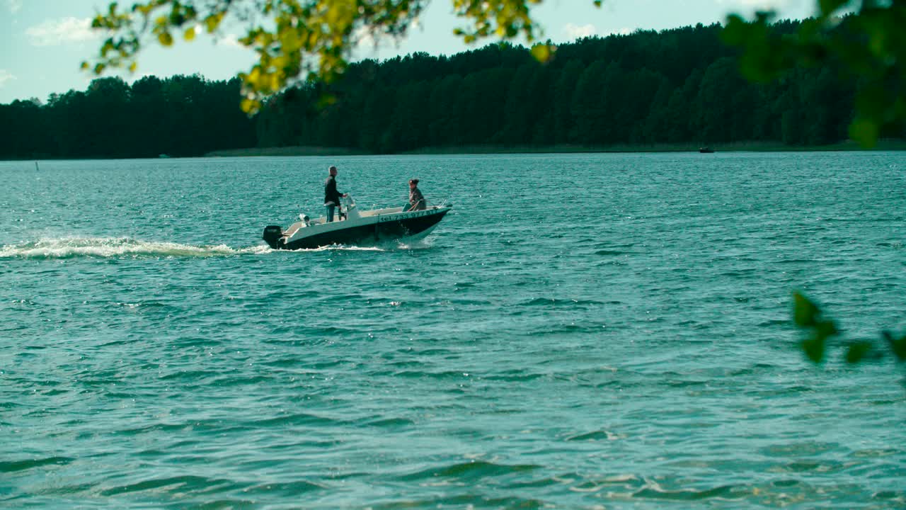 People taking a motorboat ride on the lake with beautiful forest background