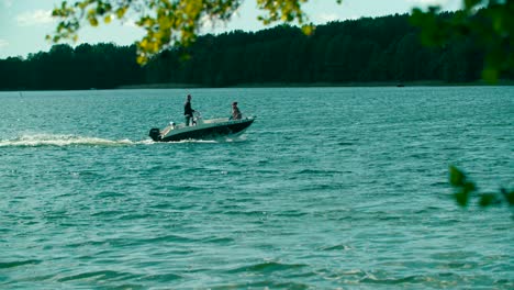 Gente-Dando-Un-Paseo-En-Lancha-Motora-Por-El-Lago-Con-Un-Hermoso-Fondo-Forestal