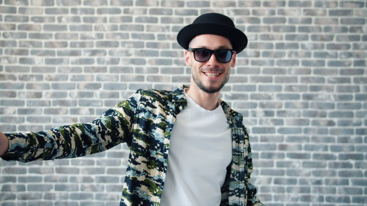 벽돌 벽 앞에 포즈를 취하는 세련된 남자