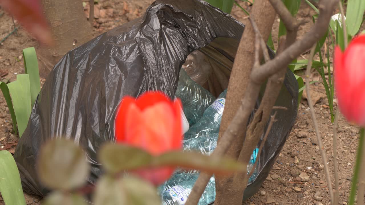 Garbage bag full of plastic bottles lies down in the garden, stop pollution, pollution of nature, garbage and nature,