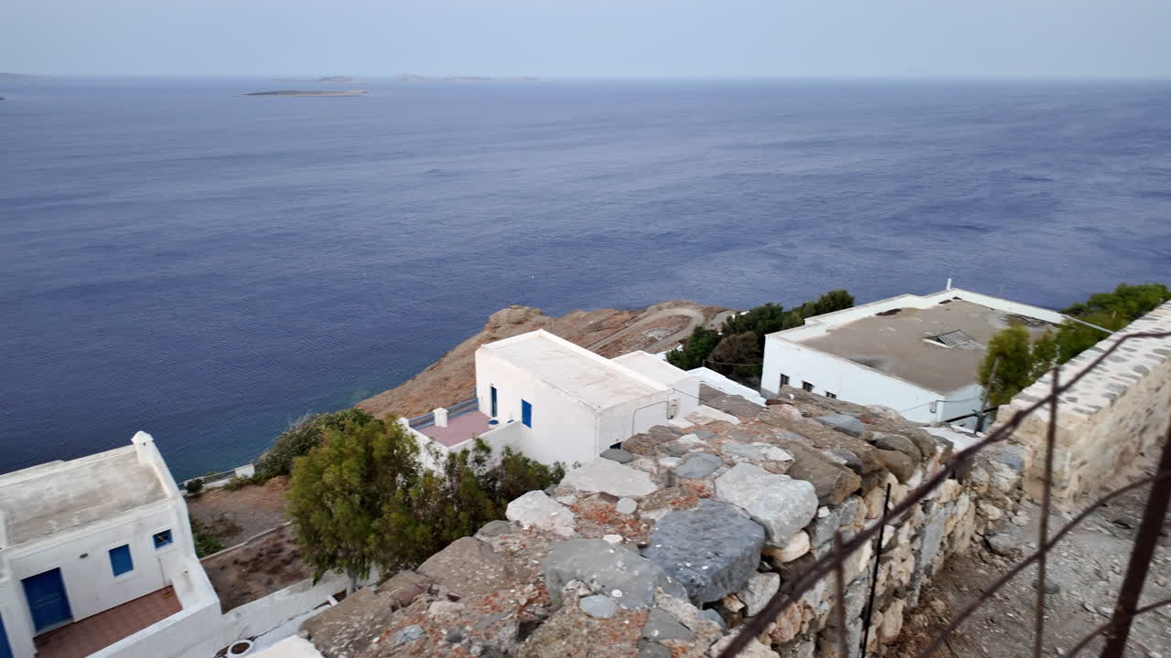 Greece, Astypalea Island, View of the island from the iconic castle during sunset. Beautiful white houses with blue doors and the Aegean sea down below. Couple of lights already turned on.