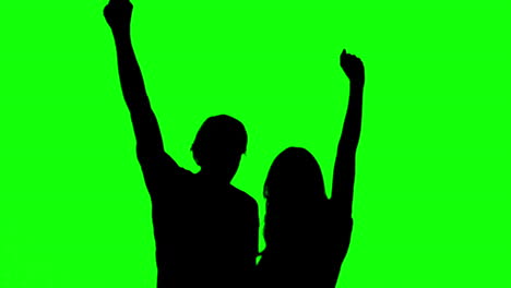 Silhouetten-Eines-Paares,-Das-Seine-Arme-Auf-Einem-Greenscreen-Hebt