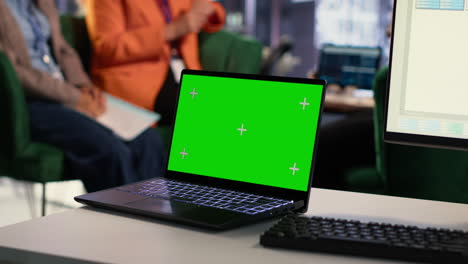 portátil con pantalla verde en una sala de reuniones