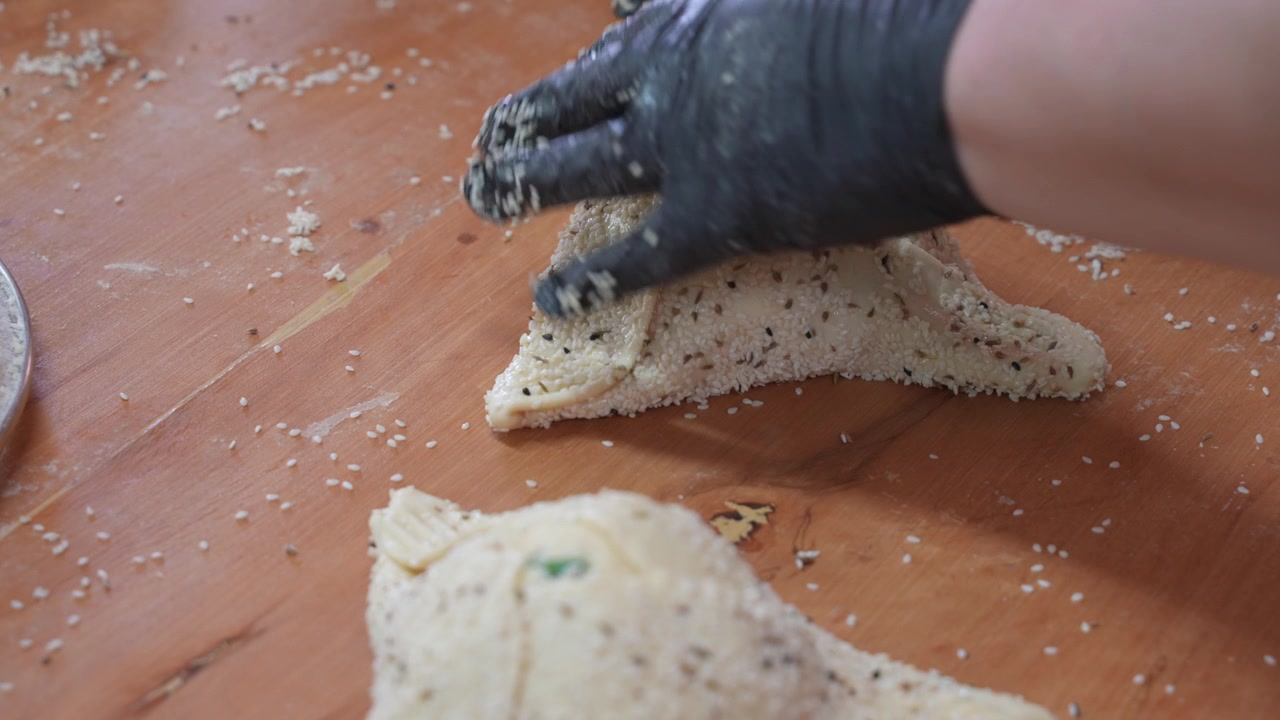Perfecting the folds on a traditional Flaouna pastry.