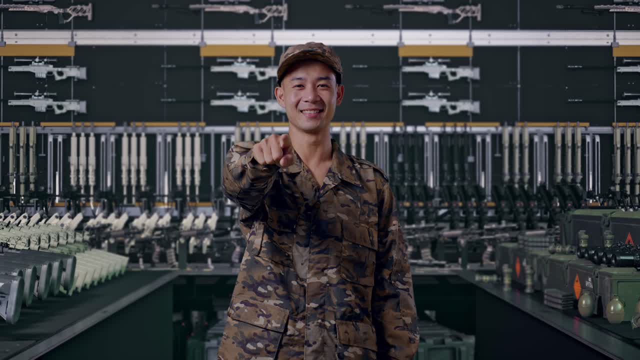 アジア人男性の兵士が微笑み、胸に触れてからあなたを指さしています（軍事兵器庫にて）。