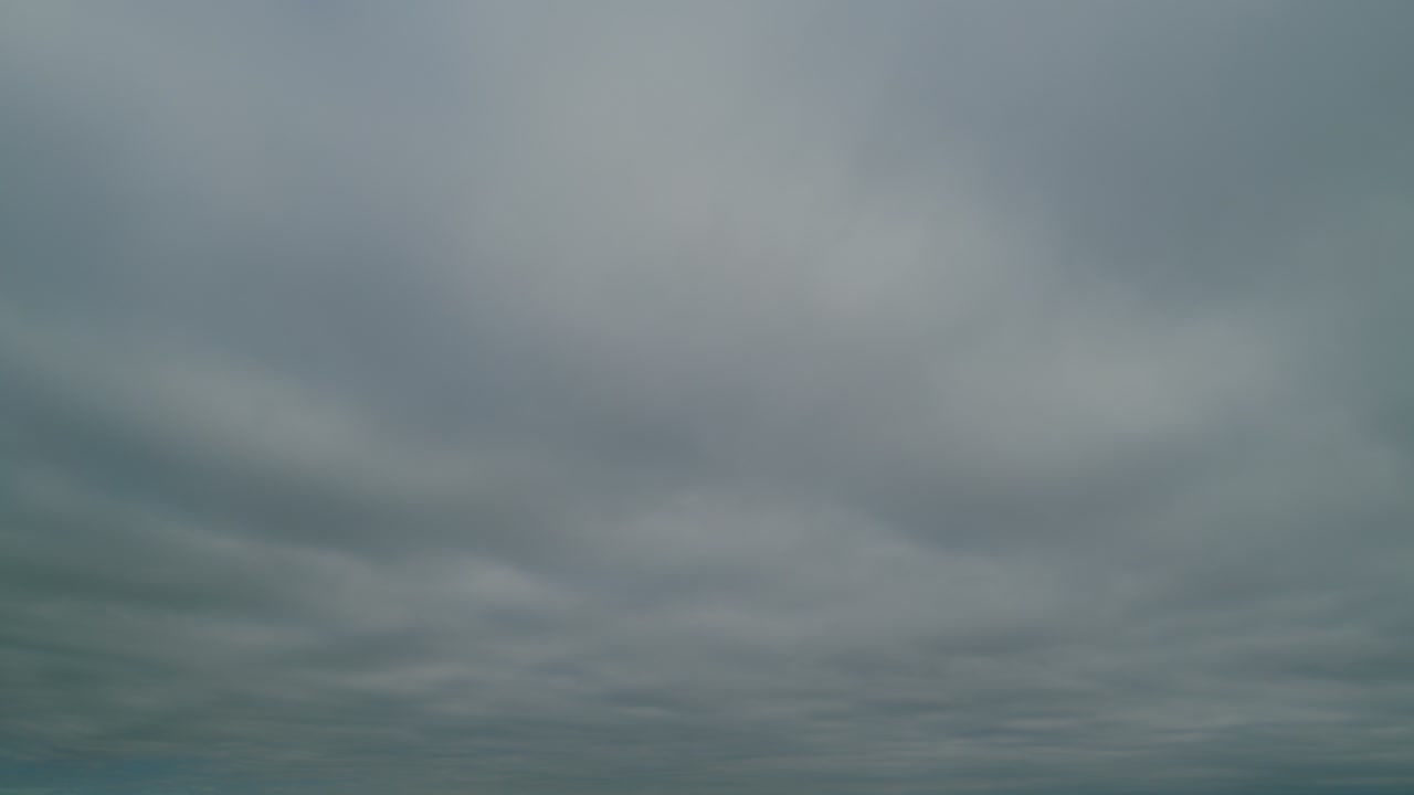 Gray, gloomy clouds dissipate and a blue sky appears. Time lapse.