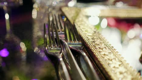 gold, detailed mirror on top of a reflecting table with forks to the right of the shot