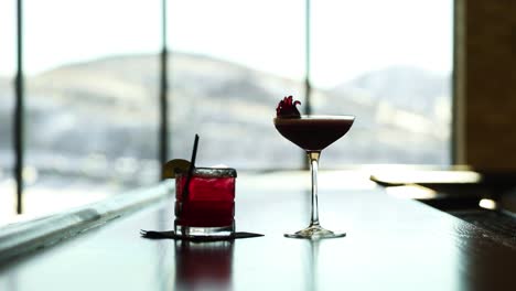 glasses of cocktail and liquor on the table with clear glass window in blurry background