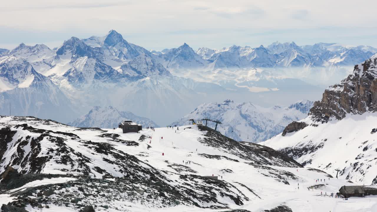 paisaje de esquiadores esquiando en los alpes italianos estación de esquí de cervinia con pico de montaña en el fondo