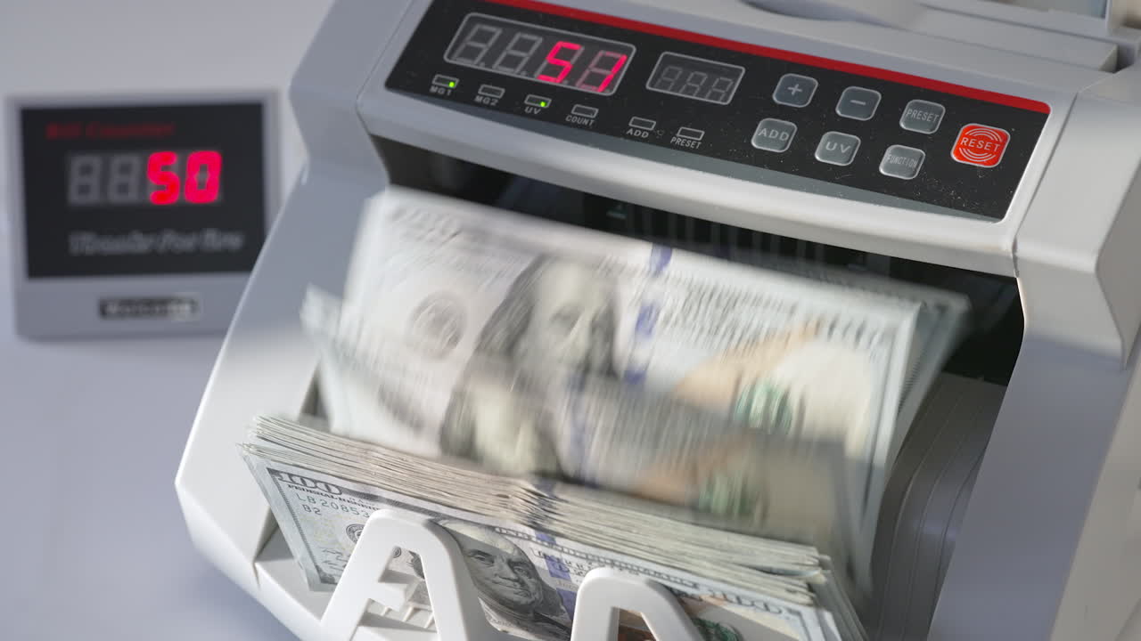 Automatic cash machine for bank operations. Modern device counting one hundred dollar bills. Close up.