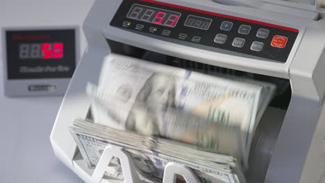 automatic cash machine for bank operations. modern device counting one hundred dollar bills. close up.