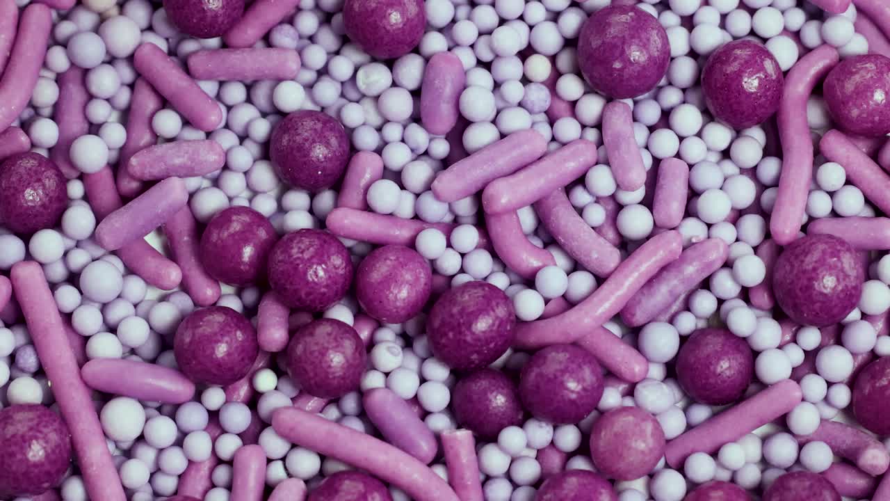 Macro view of pink and white sprinkles rotating, showcasing texture and vibrant colors in a detailed close-up