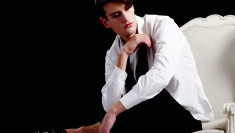 androgynous man posing against black background