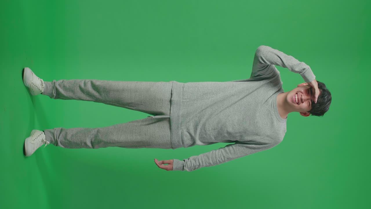 Full Body Of Asian Man Looking At Something While Standing In Front Of Green Screen Background
