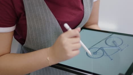 close up hands young engineers developing bicycle prototype using tablet computer viewing 3d design on touchscreen device brainstorming future development collaborating in creative office