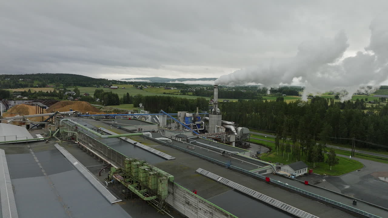 дым, поднимающийся из дымохода деревообрабатывающей фабрики в браскеридфоссе, иннленд, норвегия