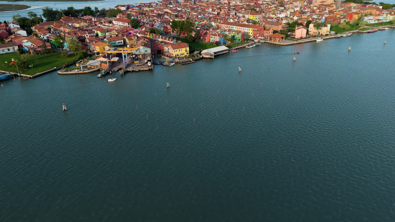 Colorful Homes Leaning Bell Tower Surrounded With Scaffoldings In Burano At Sunset - Vibrant Island In Venetian Lagoon, Italy. aerial tilt-up shot