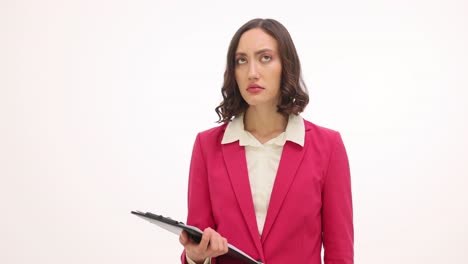professional woman in pink blazer reviewing documents on clipboard