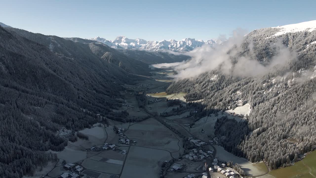 vista aérea de un valle de montaña durante el amanecer cubierto con la primera nieve de la temporada
