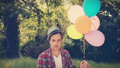 un guapo hipster con globos en la mano