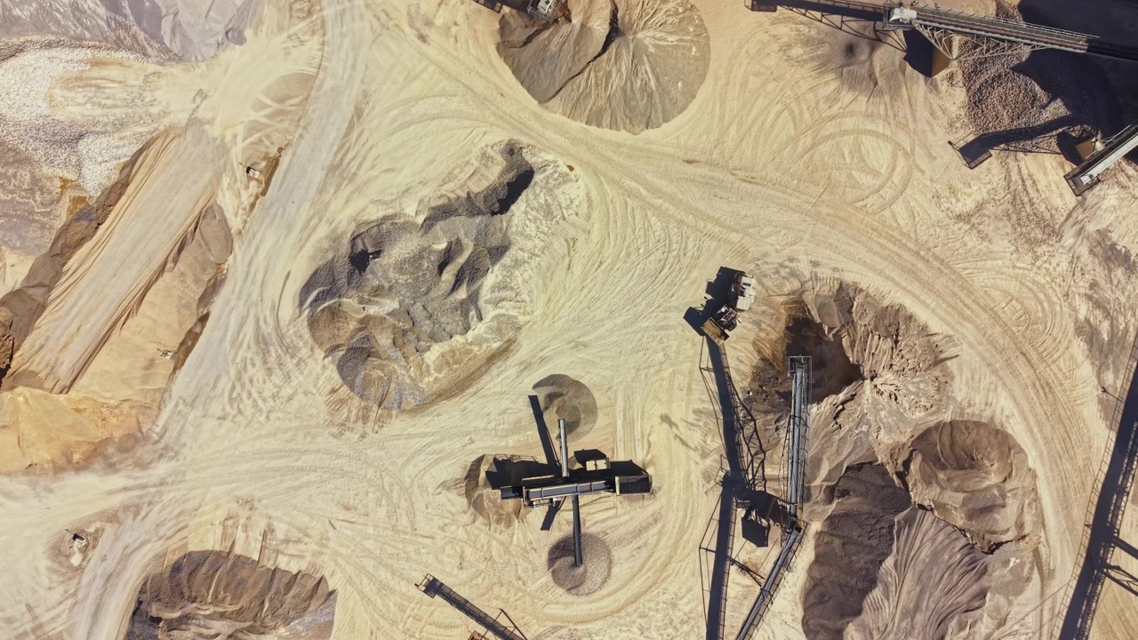 Heavy machinery works in sand and gravel pits at a construction site in broad daylight