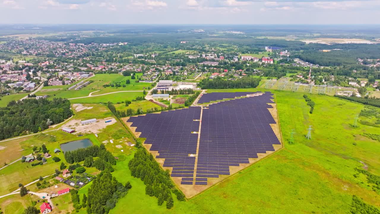 Expansive solar grid rotates slowly in focus, backed by fields and Salaspils