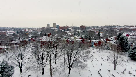 Aerial-of-cemetery,-graveyard-covered-in-winter-snow