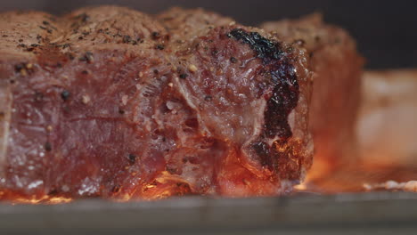 cierre el bistec de ternera sazonado cocinando a la parrilla a la parrilla en cámara lenta, 4k