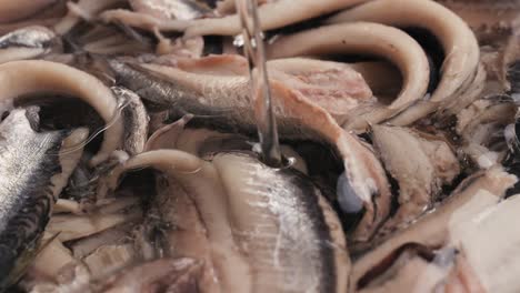 fresh sea sardines and anchovy fish and mullus on display on ice on market store shop. seafood fish background, close up stand of small salty white fish.