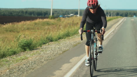 atleta femenina montando una bicicleta de triatlón al aire libre